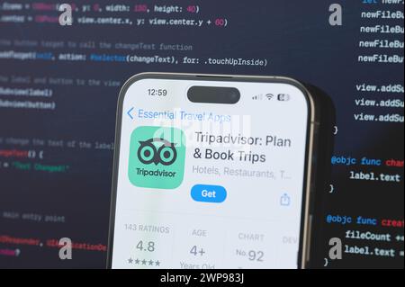 New York, USA – 23. Februar 2024: TripAdvisor auf dem iphone-Bildschirm mit unscharfem Code-Programmierhintergrund Stockfoto
