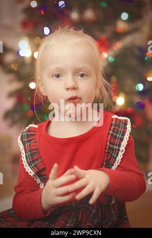 Kinder zum weihnachtsfeiertag packen Geschenke in der Nähe eines Baumes aus Stockfoto