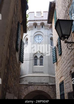 Herceg Novi, Montenegro, 08.10.2022 Sahat Kula, ein Uhrenturm, Durchgang zwischen zwei Plätzen. Es ist eine beliebte Touristenattraktion. Die Flagge von Herceg Stockfoto