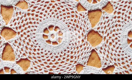 Handgehäkelte weiße Spitze. Runde Serviette für Tisch oder Kommode. Ornament im traditionellen rustikalen Stil. Ordentliche Häkel- oder Strickarbeiten. Baumwolle Stockfoto
