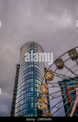 Ein Blick auf ein Hochhaus, das als Lippenstift-Gebäude bekannt ist, und ein Riesenrad auf dem Weihnachtsmarkt in Gunwharf, Portsmouth. Stockfoto