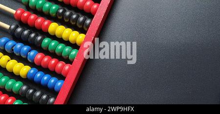 Hölzerner Abacus. Roter Holzrahmen mit Querstangen. Rote, blaue, gelbe, grüne, schwarze Holzelemente. Mathematisches Werkzeug auf schwarzem Hintergrund. Nahaufnahme. Kopieren Stockfoto