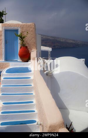 Die bezaubernde blaue Tür und die traditionelle Kykladen-Treppe führen zu einem atemberaubenden Blick auf die Ägäis in Santorin, Griechenland. Stockfoto