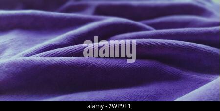 Blauer, zerknitterter Samt. Blau-violetter Samtstoff, wunderschön in Wellen gelegt. Weichzeichner. Stockfoto