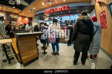 Horden von Hähnchenfinger-Liebhabern strömen zur Eröffnung des neuen Ladens von Raising Cane in Harlem in New York am Dienstag, den 27. Februar 2024. Die Fast-Food-Kette in Louisiana serviert nur Hühnerfinger-Mahlzeiten mit begleitenden Beilagen und plant, in den nächsten drei Jahren 25 Standorte in New York City zu eröffnen. Die Kette hat über 740 Restaurants in 36 bundesstaaten, im Nahen Osten und im Territorium von Guam. (© Richard B. Levine) Stockfoto