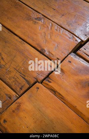 Alte zerkratzte und abgenutzte lackierte Kiefernholzdielen vom Fußgängerverkehr in einem alten Haus um 1760. Stockfoto