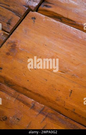 Alte zerkratzte und abgenutzte lackierte Kiefernholzdielen vom Fußgängerverkehr in einem alten Haus um 1760. Stockfoto