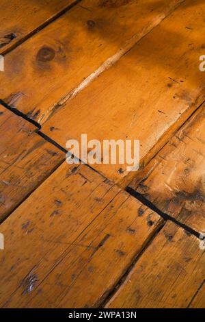 Alte zerkratzte und abgenutzte lackierte Kiefernholzdielen vom Fußgängerverkehr in einem alten Haus um 1760. Stockfoto