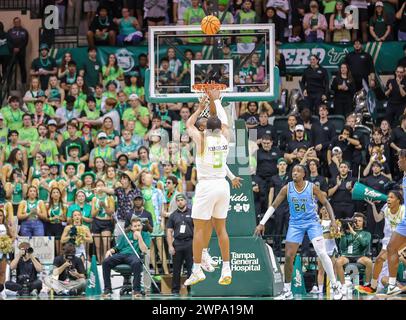 Tampa, Florida, USA. März 2024. Die University of South Florida Bulls CHRIS YOUNGBLOOD (3) schießt während des NCAA-Basketballspiels zwischen den Tulane Green Wave und der University of South Florida Bulls im Yuengling Center in Tampa, Florida, einen Sprung über den Tulane Green Wave Guard KOLBY KING (12). (Kreditbild: © Israel Anta via ZUMA Press Wire) NUR REDAKTIONELLE VERWENDUNG! Nicht für kommerzielle ZWECKE! Stockfoto