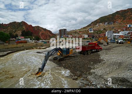 La Paz, BOLIVIEN; 6. März 2024: Instandhaltungsteams, die für die Stadtverwaltung von La Paz arbeiten, entfernen Flutschutt- und Erdrutschrückstände aus dem Fluss Irpavi in der unteren Zona Sur. Februar ist die Regenzeit und dieses Jahr war einer der nassesten Monate der Geschichte. Starke Regenfälle haben bis in den März andauert und in vielen Flusstälern und steilen, instabilen Hängen, die heute Teil der Vororte der Stadt sind, Sturzfluten, Erdrutsche und Erosion verursacht. Stockfoto