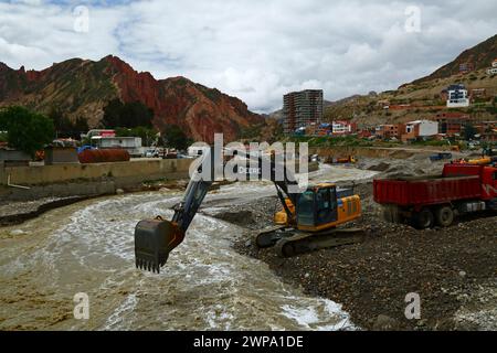 La Paz, BOLIVIEN; 6. März 2024: Instandhaltungsteams, die für die Stadtverwaltung von La Paz arbeiten, entfernen Flutschutt- und Erdrutschrückstände aus dem Fluss Irpavi in der unteren Zona Sur. Februar ist die Regenzeit und dieses Jahr war einer der nassesten Monate der Geschichte. Starke Regenfälle haben bis in den März andauert und in vielen Flusstälern und steilen, instabilen Hängen, die heute Teil der Vororte der Stadt sind, Sturzfluten, Erdrutsche und Erosion verursacht. Stockfoto