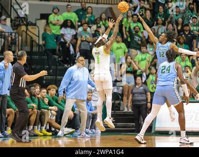 Tampa, Florida, USA. März 2024. Die University of South Florida Bulls SELTON MIGUEL (1) schießt im Yuengling Center in Tampa, Florida, einen Dreipunktschuss über den Tulane Green Wave Guard KOLBY KING (12). (Kreditbild: © Israel Anta via ZUMA Press Wire) NUR REDAKTIONELLE VERWENDUNG! Nicht für kommerzielle ZWECKE! Stockfoto