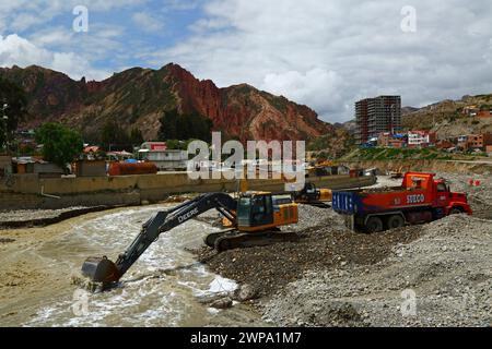 La Paz, BOLIVIEN; 6. März 2024: Instandhaltungsteams, die für die Stadtverwaltung von La Paz arbeiten, entfernen Flutschutt- und Erdrutschrückstände aus dem Fluss Irpavi in der unteren Zona Sur. Februar ist die Regenzeit und dieses Jahr war einer der nassesten Monate der Geschichte. Starke Regenfälle haben bis in den März andauert und in vielen Flusstälern und steilen, instabilen Hängen, die heute Teil der Vororte der Stadt sind, Sturzfluten, Erdrutsche und Erosion verursacht. Stockfoto