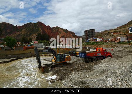 La Paz, BOLIVIEN; 6. März 2024: Instandhaltungsteams, die für die Stadtverwaltung von La Paz arbeiten, entfernen Flutschutt- und Erdrutschrückstände aus dem Fluss Irpavi in der unteren Zona Sur. Februar ist die Regenzeit und dieses Jahr war einer der nassesten Monate der Geschichte. Starke Regenfälle haben bis in den März andauert und in vielen Flusstälern und steilen, instabilen Hängen, die heute Teil der Vororte der Stadt sind, Sturzfluten, Erdrutsche und Erosion verursacht. Stockfoto