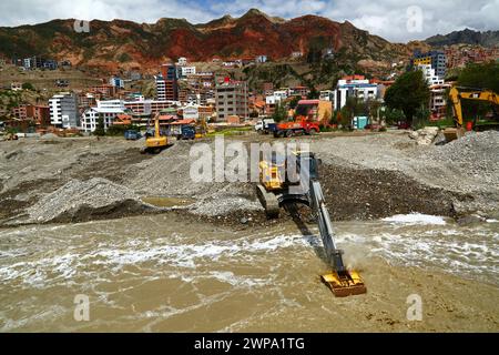 La Paz, BOLIVIEN; 6. März 2024: Instandhaltungsteams, die für die Stadtverwaltung von La Paz arbeiten, entfernen Flutschutt- und Erdrutschrückstände aus dem Fluss Irpavi in der unteren Zona Sur. Februar ist die Regenzeit und dieses Jahr war einer der nassesten Monate der Geschichte. Starke Regenfälle haben bis in den März andauert und in vielen Flusstälern und steilen, instabilen Hängen, die heute Teil der Vororte der Stadt sind, Sturzfluten, Erdrutsche und Erosion verursacht. Stockfoto