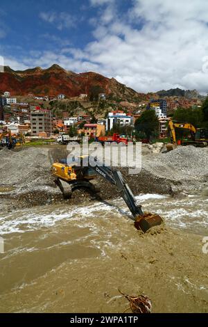 La Paz, BOLIVIEN; 6. März 2024: Instandhaltungsteams, die für die Stadtverwaltung von La Paz arbeiten, entfernen Flutschutt- und Erdrutschrückstände aus dem Fluss Irpavi in der unteren Zona Sur. Februar ist die Regenzeit und dieses Jahr war einer der nassesten Monate der Geschichte. Starke Regenfälle haben bis in den März andauert und in vielen Flusstälern und steilen, instabilen Hängen, die heute Teil der Vororte der Stadt sind, Sturzfluten, Erdrutsche und Erosion verursacht. Stockfoto