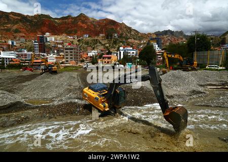 La Paz, BOLIVIEN; 6. März 2024: Instandhaltungsteams, die für die Stadtverwaltung von La Paz arbeiten, entfernen Flutschutt- und Erdrutschrückstände aus dem Fluss Irpavi in der unteren Zona Sur. Februar ist die Regenzeit und dieses Jahr war einer der nassesten Monate der Geschichte. Starke Regenfälle haben bis in den März andauert und in vielen Flusstälern und steilen, instabilen Hängen, die heute Teil der Vororte der Stadt sind, Sturzfluten, Erdrutsche und Erosion verursacht. Stockfoto