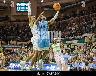 Tampa, Florida, USA. März 2024. Der Tulane Green Wave Guard KOLBY KING (12) schießt im Yuengling Center in Tampa, Florida, ein Layup, das von der University of South Florida Bulls CHRIS YOUNGBLOOD (3) während des NCAA-Basketballspiels zwischen den Tulane Green Wave und den University of South Florida Bulls angefochten wurde. (Kreditbild: © Israel Anta via ZUMA Press Wire) NUR REDAKTIONELLE VERWENDUNG! Nicht für kommerzielle ZWECKE! Stockfoto