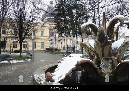 Sremska Mitrovica, Serbien 01.27.2023 Stadt Brunnen Steinblume im zentralen Park. Schneebewölkung im Winter. Schneebedeckter Stadtpark. Dekorativ Stockfoto