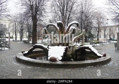 Sremska Mitrovica, Serbien 01.27.2023 Stadt Brunnen Steinblume im zentralen Park. Schneebewölkung im Winter. Schneebedeckter Stadtpark. Dekorativ Stockfoto