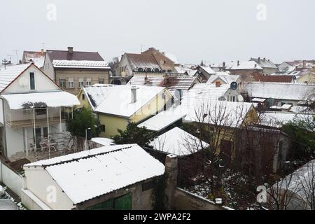 Sremska Mitrovica, Serbien, 01.27.2023 Schneefall in der Stadt. Mit Schnee bedeckte Dächer von Häusern. Wettervorhersage. Bewölkter Wintertag. Stadtlandschaft Stockfoto