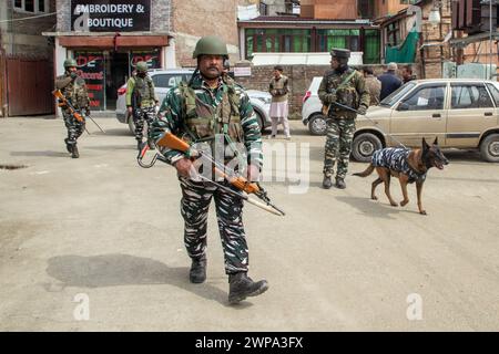 Srinagar, Indien. März 2024. Indische paramilitärische Truppen patrouillieren zusammen mit einem Schnüfferhund in der Nähe des Veranstaltungsorts, an dem der indische Premierminister Narendra Modi am 7. März eine öffentliche Kundgebung halten soll. Vor dem ersten Besuch des indischen Premierministers Narendra Modi im Tal seit der Aufhebung des Artikels 370 im Jahr 2019 sind Sicherheitsbeamte im Kaschmir-Tal auf der Hut, wodurch der besondere halbautonome Status der Region beendet wird. (Foto: Faisal Bashir/SOPA Images/SIPA USA) Credit: SIPA USA/Alamy Live News Stockfoto