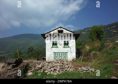 Weißes Backsteinhaus mit Rissen ist nach einem Erdbeben im Himalaya in Nepal verlassen, auf dem Weg zwischen Jiri und Lukla - unterer Teil des Everest Treks Stockfoto