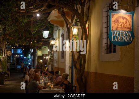 RETHYMNO, INSEL KRETA, GRIECHENLAND - 23. JUNI 2021: Nachtblick mit kleinen und malerischen Straßenterrassen mit Touristen, im historischen Zentrum Stockfoto