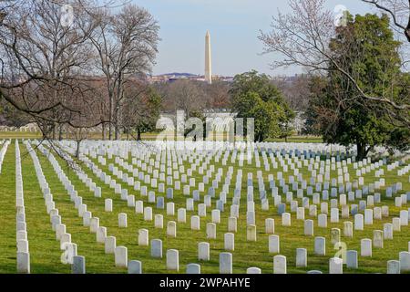 Reihen von Grabsteinen auf dem Arlington National Cemetery mit dem Washington Monument im Hintergrund Stockfoto