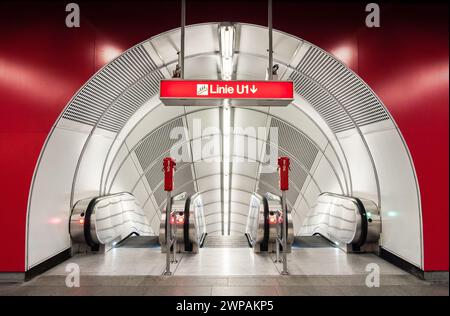 Fahrtreppen der U-Bahn-Station - symmetrische Ansicht. Eingang von Halle mit roten Wänden in leeren weißen Tunnel mit drei beweglichen Treppen. Stockfoto