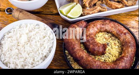 Typischer Esstisch im Inneren Brasiliens. Schweinefleisch, Bohnen, Bohnen-Tutu, Schweineschalen, Reis und Farofa. Gastronomisches Tursimo-Konzept, Foto für Restaurant m Stockfoto