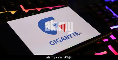 Viersen, Deutschland - 9. Februar. 2024: Nahaufnahme des Smartphones mit Logo-Schriftzug der Gigabyte-Technologie auf der Computertastatur Stockfoto