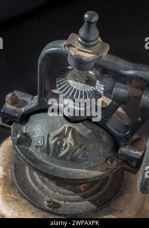 Detail der antiken Kaffeebohne Original-Mahlwerk Metall-Rüttelrad mit Handkurbel auf dunklem Hintergrund. Nahaufnahme der alten Original Kaffeemühle, Space Fo Stockfoto