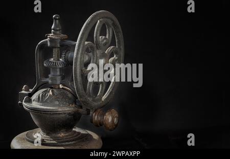 Detail der antiken Kaffeebohne Original-Mahlwerk Metall-Rüttelrad mit Handkurbel auf dunklem Hintergrund. Nahaufnahme der alten Original Kaffeemühle, Space Fo Stockfoto
