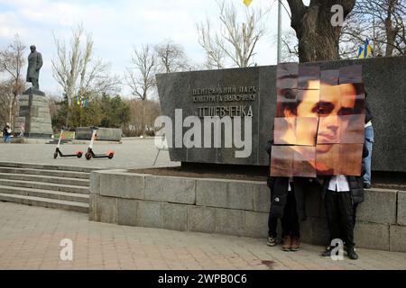 Odessa, Ukraine. März 2024. Studenten der Odessa Höheren Berufsschule für Handel und Lebensmitteltechnologie haben ein Puzzle mit dem Gesicht von Taras Schewtschenko vor dem Hintergrund des gleichnamigen Denkmals im Central Park für Kultur und Freizeit, benannt nach Taras Grigoriewitsch Schewtschenko, zusammengestellt. Junge Patrioten veranstalten eine Veranstaltung, die dem Geburtstag des berühmten ukrainischen Dichters gewidmet ist. Taras Hryhorovych Schewtschenko (* 9. März 1814, 10. März 1861) war ein ukrainischer Dichter, Schriftsteller, Künstler, öffentliche und politische Persönlichkeit, Folklorist und Ethnograph. Er war Fellow der Kaiserlichen Akademie der Künste Stockfoto