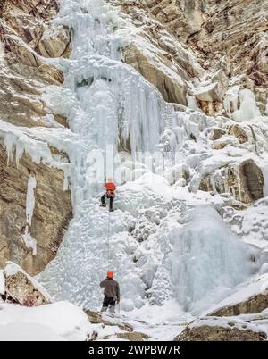Eiskletterer auf dem gefrorenen Katarakt fallen entlang der felsigen Bergfront in der Nähe von augusta, montana Stockfoto