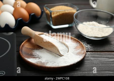 Backpulver und andere Produkte auf schwarzem Holztisch, Nahaufnahme Stockfoto