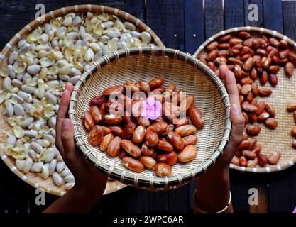 Top View Korb mit Jackfruit Samen, Frau Hand halten Fruchtsamen auf rohen Zutaten Lebensmittel Hintergrund Stockfoto