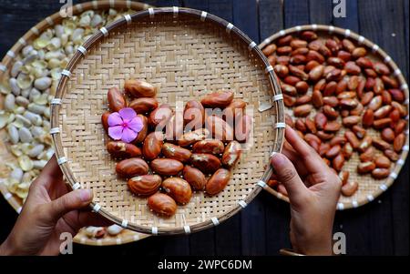 Top View Korb mit Jackfruit Samen, Frau Hand halten Fruchtsamen auf rohen Zutaten Lebensmittel Hintergrund Stockfoto