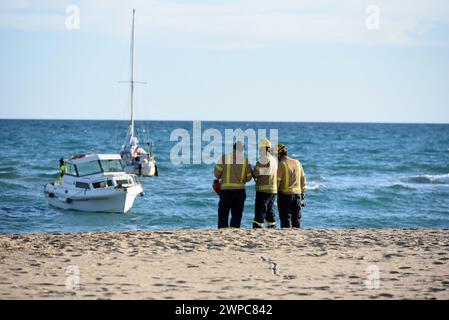 Vendrell, Spanien. März 2024. Eine Gruppe von Feuerwehrleuten der katalanischen Regierung beobachtet das Segelboot, das am Strand von Sant Salvador gestrandet ist. Ein Seerettungsschiff der spanischen Regierung rettet und begleitet auf hoher See ein 7 Meter langes Segelboot, das aus meteorologischen Gründen am Strand Sant Salvador in der Stadt Vendrell in Tarragona Spanien mit Hilfe der Feuerwehrmänner der Regierung Kataloniens und der Regierung Kataloniens auf Grund lief Katalanische Polizei. Quelle: SOPA Images Limited/Alamy Live News Stockfoto