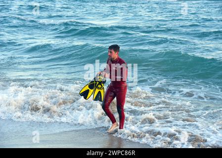 Vendrell, Spanien. März 2024. Ein Feuerwehrmann der katalanischen Regierung kommt aus dem Wasser, nachdem er das Segelboot am Strand von Sant Salvador gerettet hat. Ein Seerettungsschiff der spanischen Regierung rettet und begleitet auf hoher See ein 7 Meter langes Segelboot, das aus meteorologischen Gründen am Strand Sant Salvador in der Stadt Vendrell in Tarragona Spanien mit Hilfe der Feuerwehrmänner der Regierung Kataloniens und der Regierung Kataloniens auf Grund lief Katalanische Polizei. Quelle: SOPA Images Limited/Alamy Live News Stockfoto