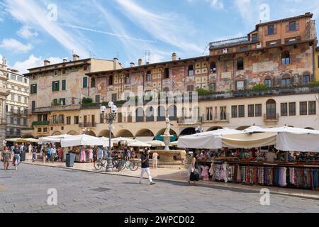 Touristen an der Piazza delle Erbe mit Gebäuden aus verschiedenen Jahrhunderten in der Altstadt von Verona in Italien Stockfoto