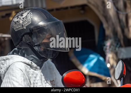 YALA, THAILAND, 1. März 2024, Eine Frau fährt ein Motorrad in einem Helm mit einem Abdruck Stockfoto