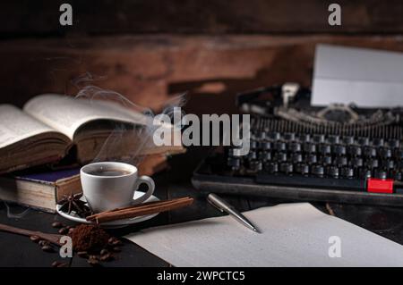 Foto eines Buches, einer Tasse Kaffee und einer Schreibmaschine auf einem Schreibtisch Stockfoto