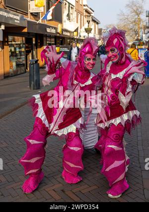 Noordwijkerhout, Niederlande - 21. April 2023: Frauen in rosa Märchenkostümen auf der Straße in Noordwijkerhout vor dem Abend erleuchtete Flowe Stockfoto