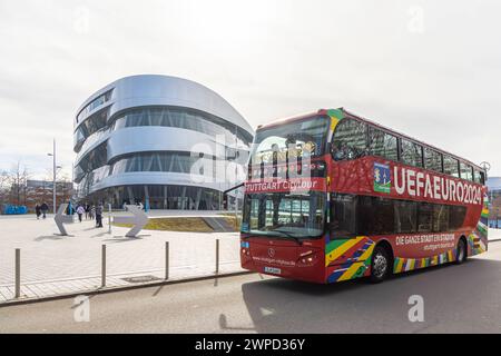 Stuttgrt Stadtbesichtigung. Stadtrundfahrt im roten Doppeldecker. Stadtansicht Stuttgart vor dem Mercedes-Benz Museum und der Mercedes Benz Welt in Bad Cannstatt. FußballEuropameisterschaft UEFA EURO 2024 in Deutschland, fünf Spiele des Turniers werden in Stuttgart ausgetragen. Außerdem sind in der Innenstadt ein großes Public Viewing und viele weitere Attraktionen geboten. // 03.03.2024: Stuttgart, Baden-Württemberg, Deutschland, Europa *** Stuttgrt Citytour City Tour im roten DoppeldeckerCity View von Stuttgart vor dem Mercedes Benz Museum und der Mercedes Benz World in Bad Cannstatt Europea Stockfoto