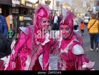 Noordwijkerhout, Niederlande - 21. April 2023: Frauen in rosa Märchenkostümen auf der Straße in Noordwijkerhout vor dem Abend erleuchtete Flowe Stockfoto