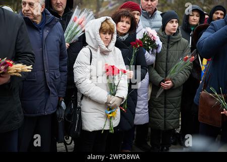 Verwandte der gefallenen Euromaidaner-Aktivisten brachten am Tag der Helden der Himmlischen Hundert Blumen an das Denkmal. Kiew - 20. Februar 2024 Stockfoto
