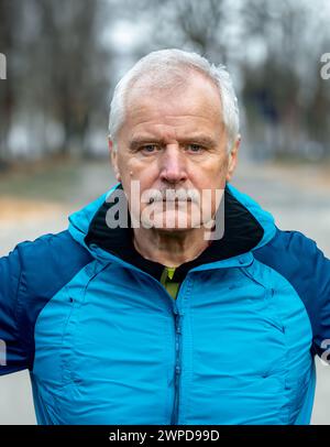 Senior Mann in Sportkleidung, der in die Kamera schaut. Symbol für ältere Menschen, die aktiv sind und trainieren. Stockfoto