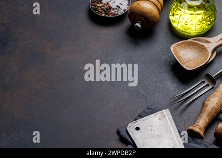 Kulinarisches Essential: Diverse Kochutensilien und Gewürze auf Steintisch. Mit Kopierraum Stockfoto